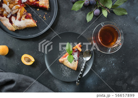 Cup of tea and tasty fall pie galette with plum. 56657899