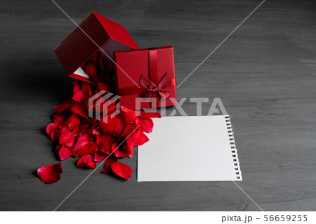 Beautiful red roses next to a gift red box on a 56659255
