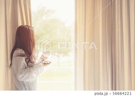 Asian woman in bedroom drinking coffee 56664221