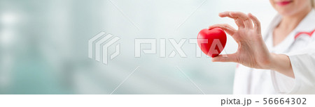 Doctor holding a red heart at hospital office. Doctor holding a red heart at hospital office. 56664302