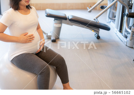 Active pregnant woman exercise in fitness center. Active pregnant woman exercise in fitness center. 56665102