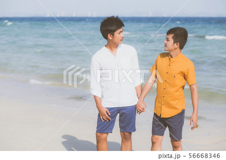 Homosexual young asian couple standing on beach Homosexual young asian couple standing on beach 56668346