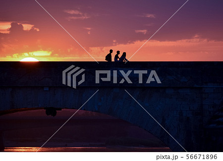 Silhouette of young friends on a colorful sunset 56671896