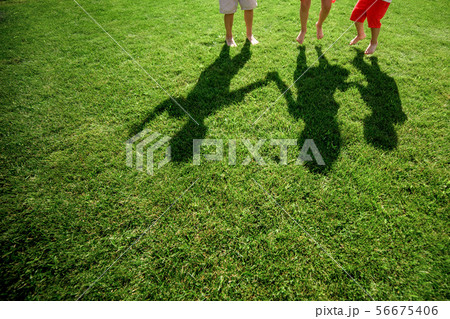 Kids with their shadows on grass.  56675406