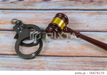 Judge gavel and handcuffs on wooden background. 56678170