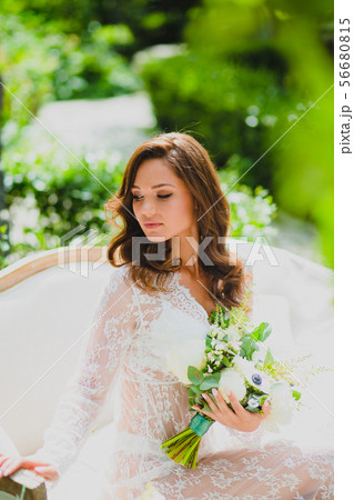 Close-up portrait of young beautiful bride in white negligee with bridal bouquet Close-up portrait of young beautiful bride in white negligee with bridal bouquet 56680815