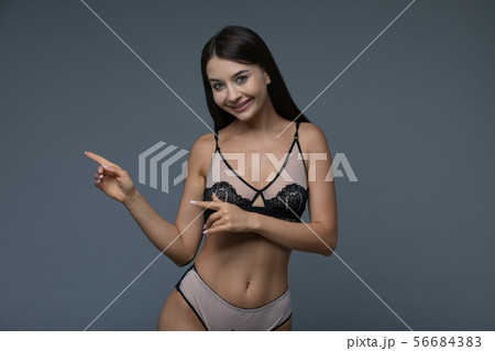 Happy brunette woman pointing to with her fingers Happy brunette woman pointing to with her fingers 56684383