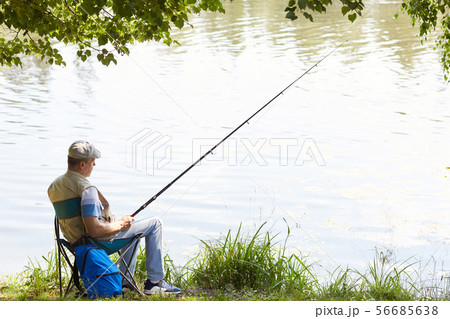 Man relaxing at the lakeside Man relaxing at the lakeside 56685638