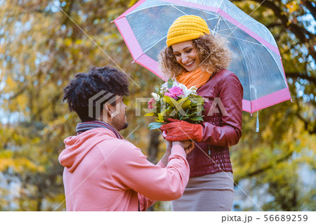 Black man proposing to Caucasian girl who happily accepts 56689259