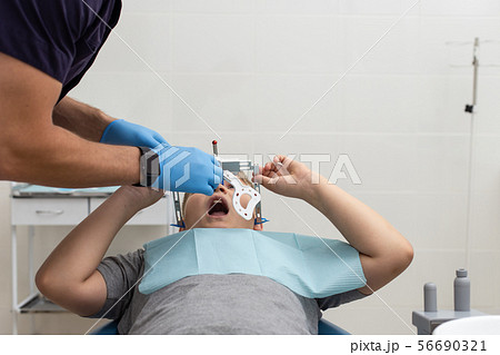 Doctor preparing his patient for fixing up orthodontic arch 56690321