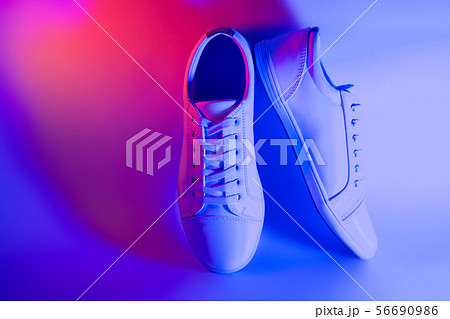 White trendy fashionable sneakers in neon light. White trendy fashionable sneakers in neon light. 56690986