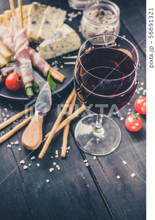 Close-up glass of red wine, snacks, jamon, cheese 56691321