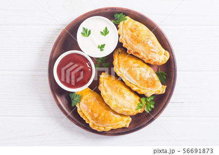 Latin American baked beef empanadas with sauce 56691873