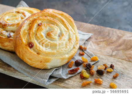 Freshly baked bun with raisins on a linen napkin. 56695691