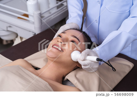woman receiving ultrasound facial beauty treatment woman receiving ultrasound facial beauty treatment 56698009