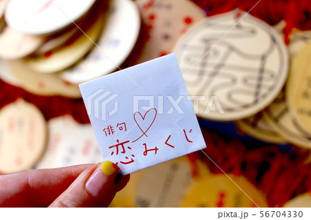 【愛媛】松山　圓満寺　絵馬を背景に女性が持つ俳句恋みくじ 56704330