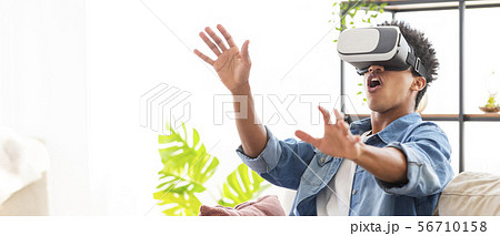 Joyful black guy using VR headset at home 56710158