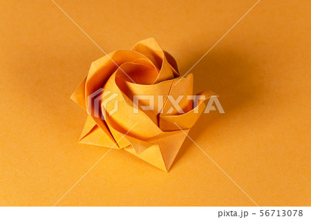 Orange origami rose on orange background Orange origami rose on orange background 56713078