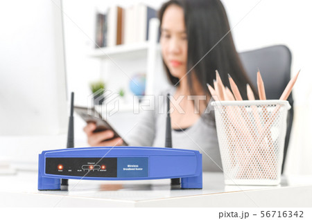 Wireless router and woman using a smartphone  in 56716342