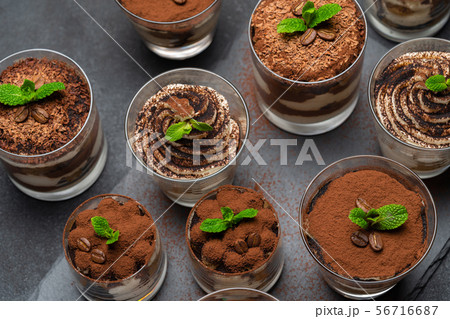 Group of portions of Classic tiramisu dessert in a glass cup on stone board on concrete background Group of portions of Classic tiramisu dessert in a glass cup on stone board on concrete background 56716687