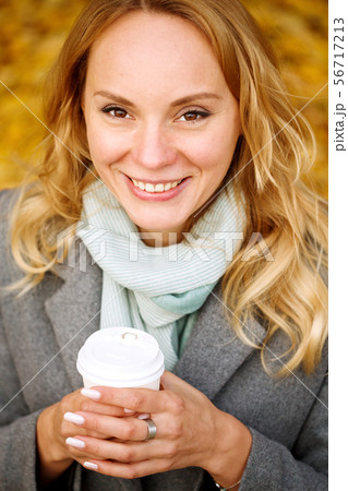 Cheerful pretty woman drinking coffee in autumn 56717213