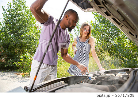 Young multiethnic international couple traveling on the car in sunny day Young multiethnic international couple traveling on the car in sunny day 56717809