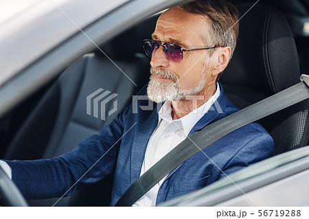 Mature businessman with sunglasses concentrating Mature businessman with sunglasses concentrating 56719288