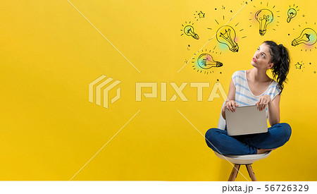 Idea light bulbs with woman using a laptop 56726329