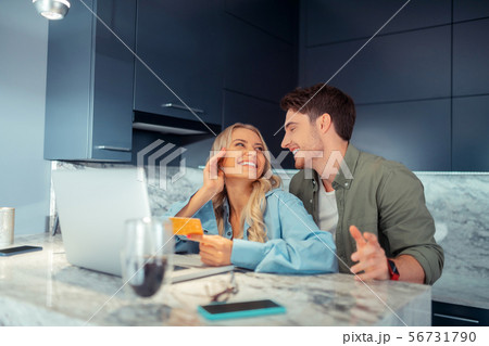 Couple laughing while shopping online at the weekend together Couple laughing while shopping online at the weekend together 56731790