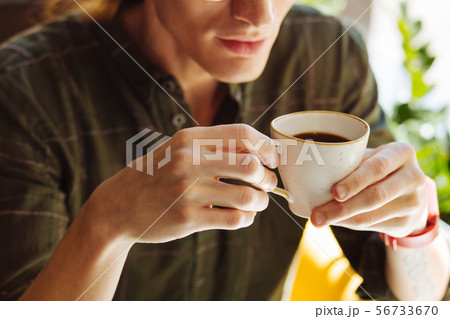 Close up of a cup with coffee in male hands Close up of a cup with coffee in male hands 56733670