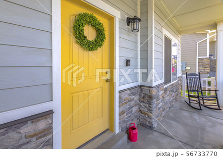 yellow front door with rocking chair 56733770