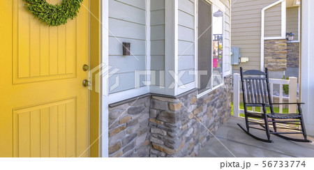 Yellow front door and porch with a rocking chair Yellow front door and porch with a rocking chair 56733774