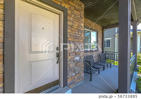 White front door of home with furniture on porch 56733895