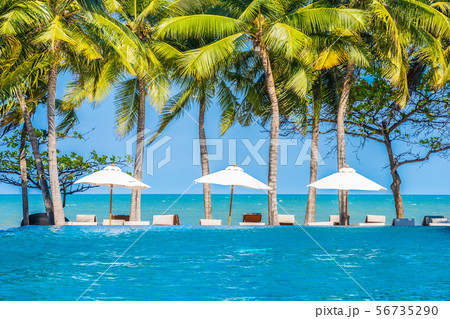 Umbrella and chair around swimming pool in hotel resort neary sea ocean beach for vacation 56735290