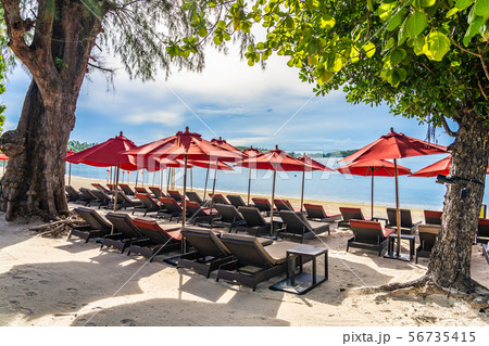 Beautiful outdoor tropical beach sea ocean with umbrella chair and lounge deck around there on white cloud blue sky Beautiful outdoor tropical beach sea ocean with umbrella chair and lounge deck around there on white cloud blue sky 56735415