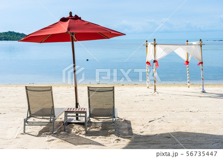 Beautiful outdoor tropical beach sea ocean with umbrella chair and lounge deck around there on white cloud blue sky Beautiful outdoor tropical beach sea ocean with umbrella chair and lounge deck around there on white cloud blue sky 56735447