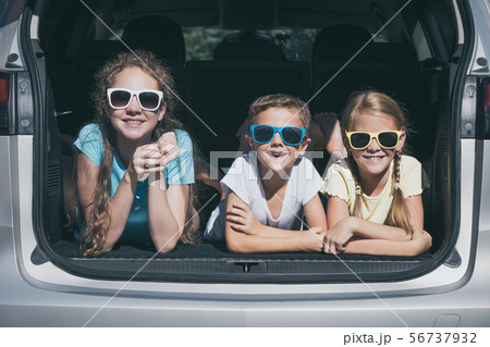 Happy brother and his two sisters are sitting in Happy brother and his two sisters are sitting in 56737932
