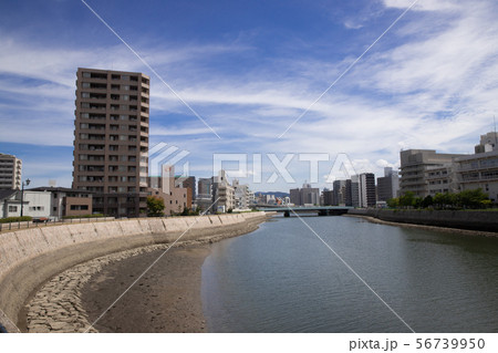 青空と河川敷沿いの街並み 56739950