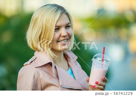 Girl with milkshake , defocused background Girl with milkshake , defocused background 56741229