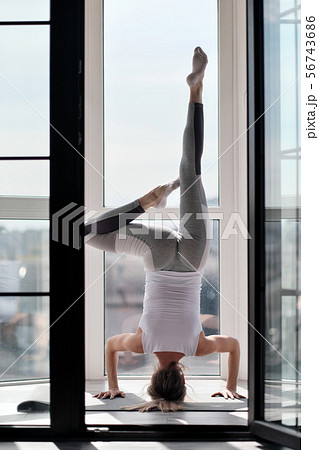 Young beautiful athletic woman blonde in white sportswear doing yoga and stretching on the balcony 56743686