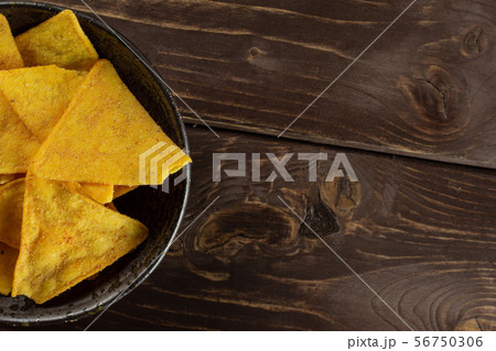 Tortilla cheese chips on brown wood Tortilla cheese chips on brown wood 56750306