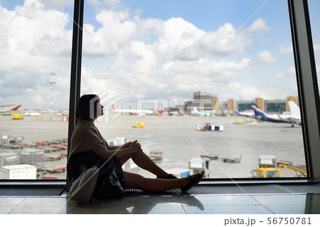 Woman with a backpack and a travel pillow sitting Woman with a backpack and a travel pillow sitting 56750781