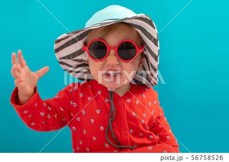 Stylish playful kid in sunglasses and striped hat 56758526
