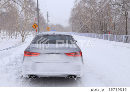 冬季の悪天候(吹雪)で雪が付着した車 56759316