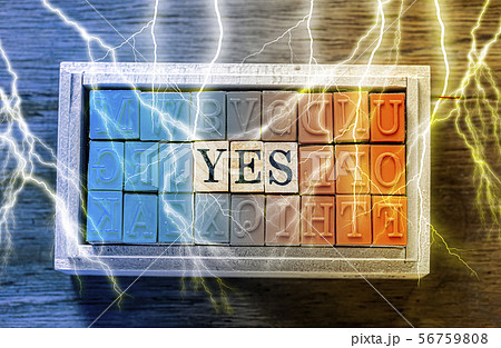 木目の上に置いたハンコ　YES の文字と木目の背景と青とオレンジと稲妻（雷） 56759808