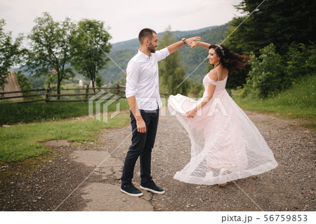 Beautiful wedding couple in Carpathian mountains. Handsome man with attractive woman. Bride spin 56759853