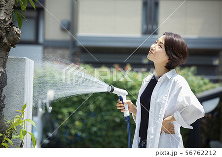 女性 ホース 水やり 水撒きの写真素材