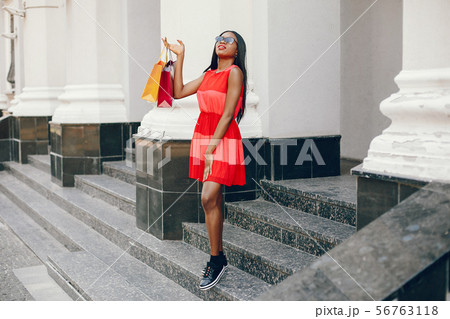 Beautiful black girl with shopping bags in a city 56763118