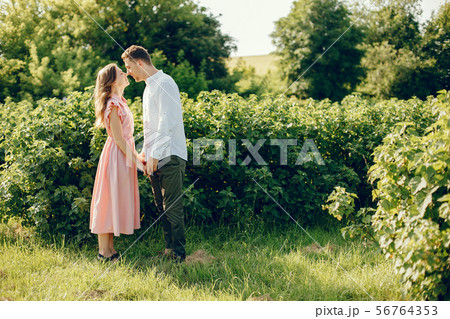 Beautiful couple spend time on a summer field Beautiful couple spend time on a summer field 56764353