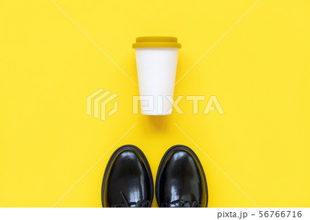 Black boots and a bamboo cup with a plastic lid for coffee to go Black boots and a bamboo cup with a plastic lid for coffee to go 56766716